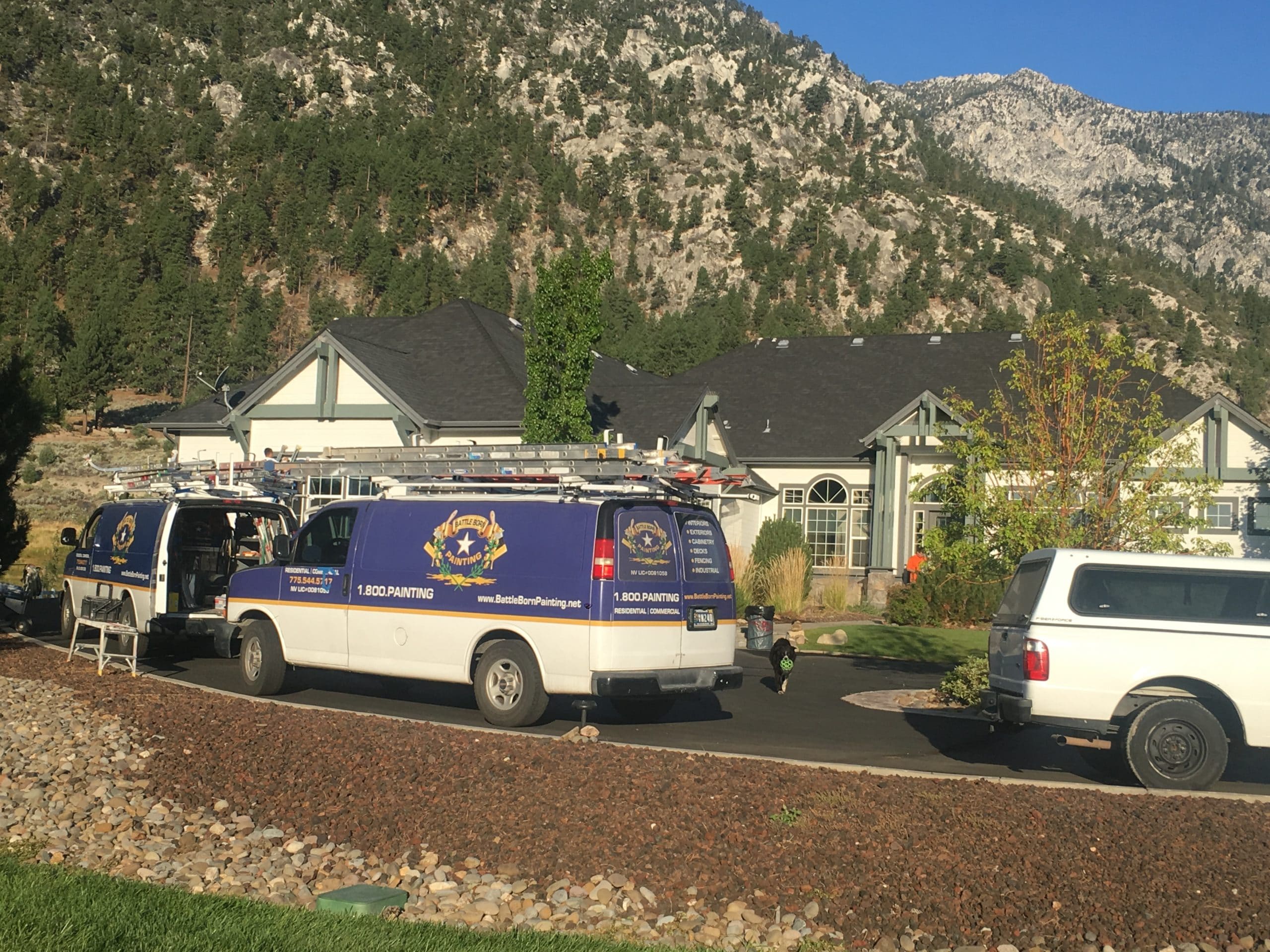 Battle Born Painting work vans parked outside a Reno home they are painting
