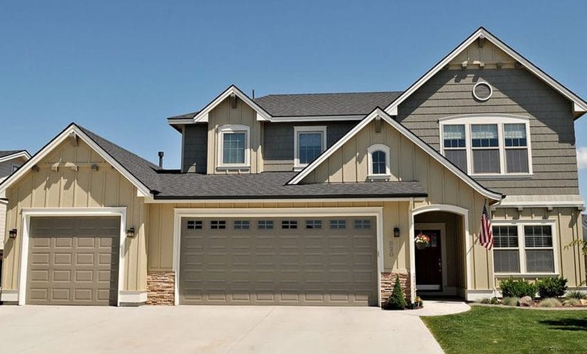 Two-story home freshly painted gray with white trim and a three-car garage