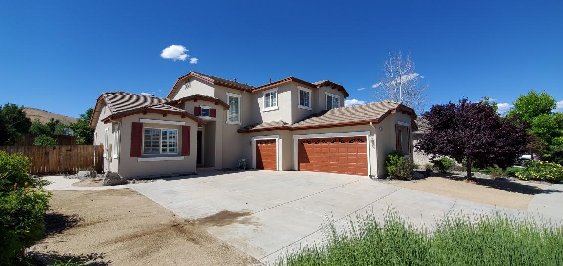 Two-story stucco home with fresh exterior paint and a wide driveway